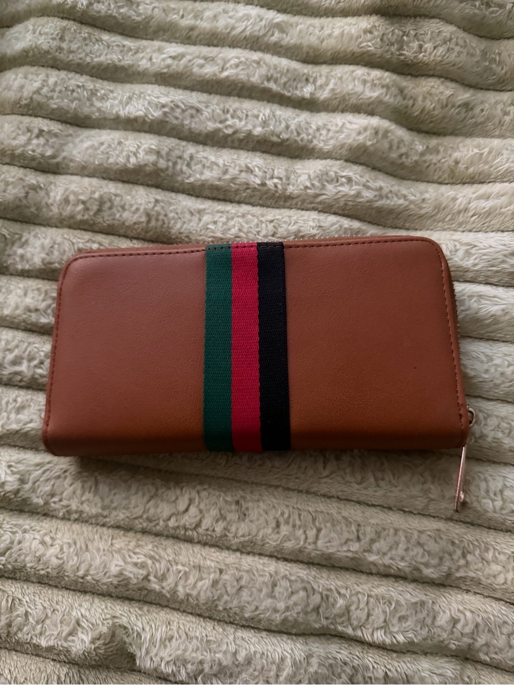 Brown wallet with green red and black stripes.